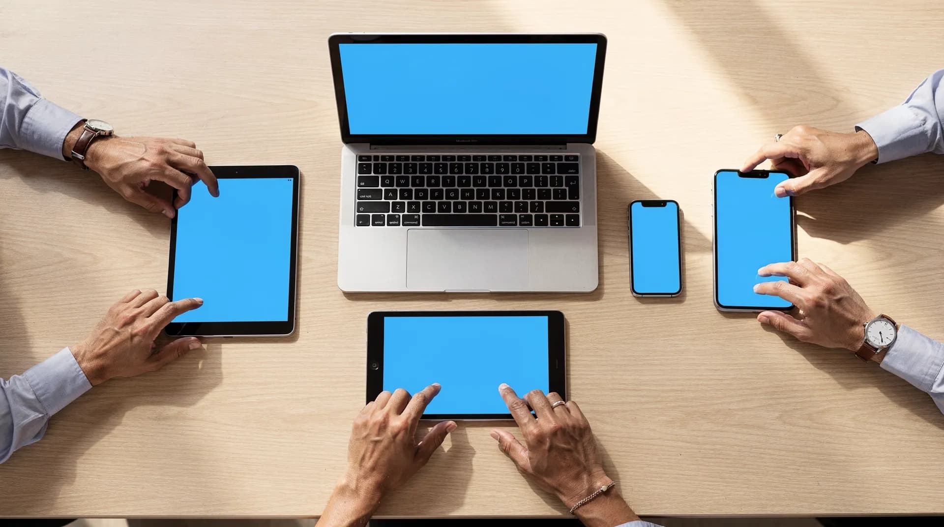 Multiple laptops and devices on a table showing cross-platform web access